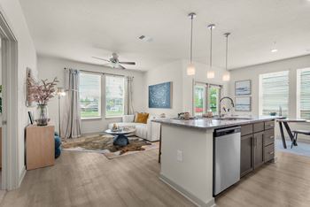 an open living room and kitchen with a ceiling fan at The Enclave at Deer Moss Creek, Niceville, FL, 32578